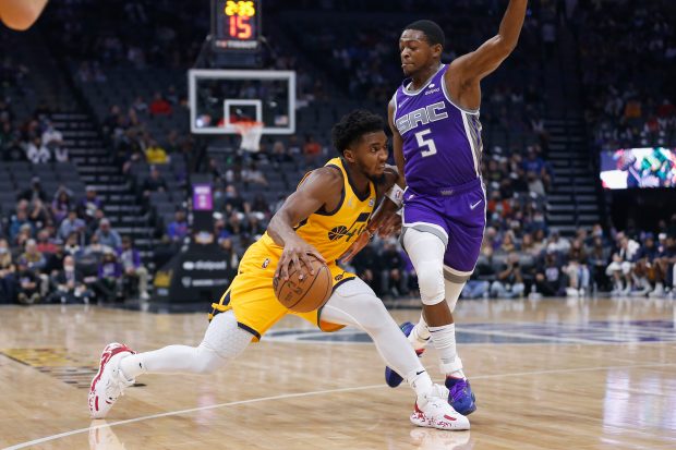 SACRAMENTO, CALIFORNIA - NOVEMBER 20: Donovan Mitchell #45 of the Utah Jazz is guarded by De'Aaron Fox #5 of the Sacramento Kings in the second quarter at Golden 1 Center on November 20, 2021 in Sacramento, California. NOTE TO USER: User expressly acknowledges and agrees that, by downloading and/or using this photograph, User is consenting to the terms and conditions of the Getty Images License Agreement. (Photo by Lachlan Cunningham/Getty Images)