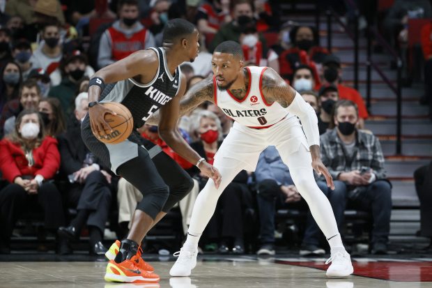 PORTLAND, OREGON - OCTOBER 20: Damian Lillard #0 of the Portland Trail Blazers defends De'Aaron Fox #5 of the Sacramento Kings during the first quarter at Moda Center on October 20, 2021 in Portland, Oregon. NOTE TO USER: User expressly acknowledges and agrees that, by downloading and or using this photograph, User is consenting to the terms and conditions of the Getty Images License Agreement. (Photo by Steph Chambers/Getty Images)