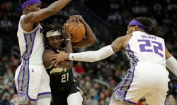 MILWAUKEE, WISCONSIN - JANUARY 22: Jrue Holiday #21 of the Milwaukee Bucks drives to the basket between two Sacramento Kings defenders during the first half of a game at Fiserv Forum on January 22, 2022 in Milwaukee, Wisconsin. NOTE TO USER: User expressly acknowledges and agrees that, by downloading and or using this photograph, User is consenting to the terms and conditions of the Getty Images License Agreement. (Photo by John Fisher/Getty Images)