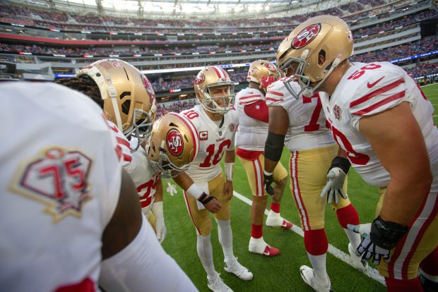 INGLEWOOD, CA - JANUARY 30: Jimmy Garoppolo #10 of the San Francisco 49ers call a play in a huddle before the game against the Los Angeles Rams at SoFi Stadium on January 30, 2022 in Inglewood, California. The Rams defeated the 49ers 20-17. (Photo by Michael Zagaris/San Francisco 49ers/Getty Images)