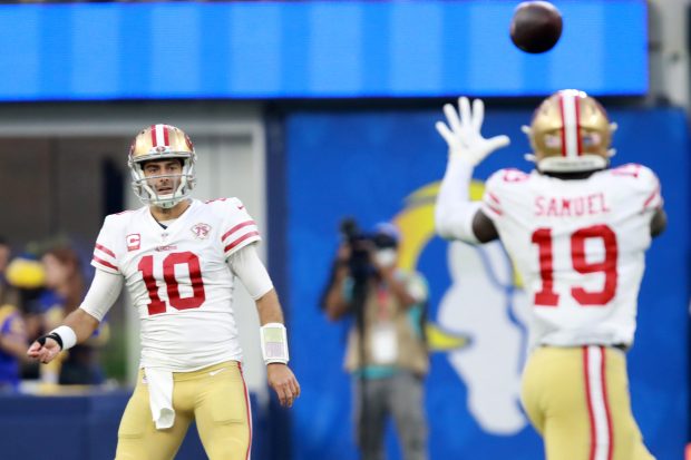 INGLEWOOD, CALIFORNIA - JANUARY 09: Jimmy Garoppolo #10 of the San Francisco 49ers passes to Deebo Samuel #19 in overtime against the Los Angeles Rams at SoFi Stadium on January 09, 2022 in Inglewood, California. (Photo by Joe Scarnici/Getty Images)